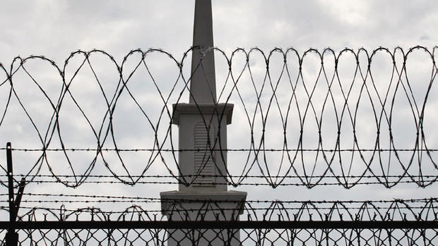 In a Friday, Sept. 18, 2009 photo, a view through barbed-wire is seen of a chapel located on th egrounds of the Louisiana State Penitentiary, in Angola, La. About 150 prisoners at Angola so far have earned Bachelor of Arts degrees from the New Orleans Baptist Theological Seminary, and another 100 are on track to graduate.  (AP Photo/Judi Bottoni)